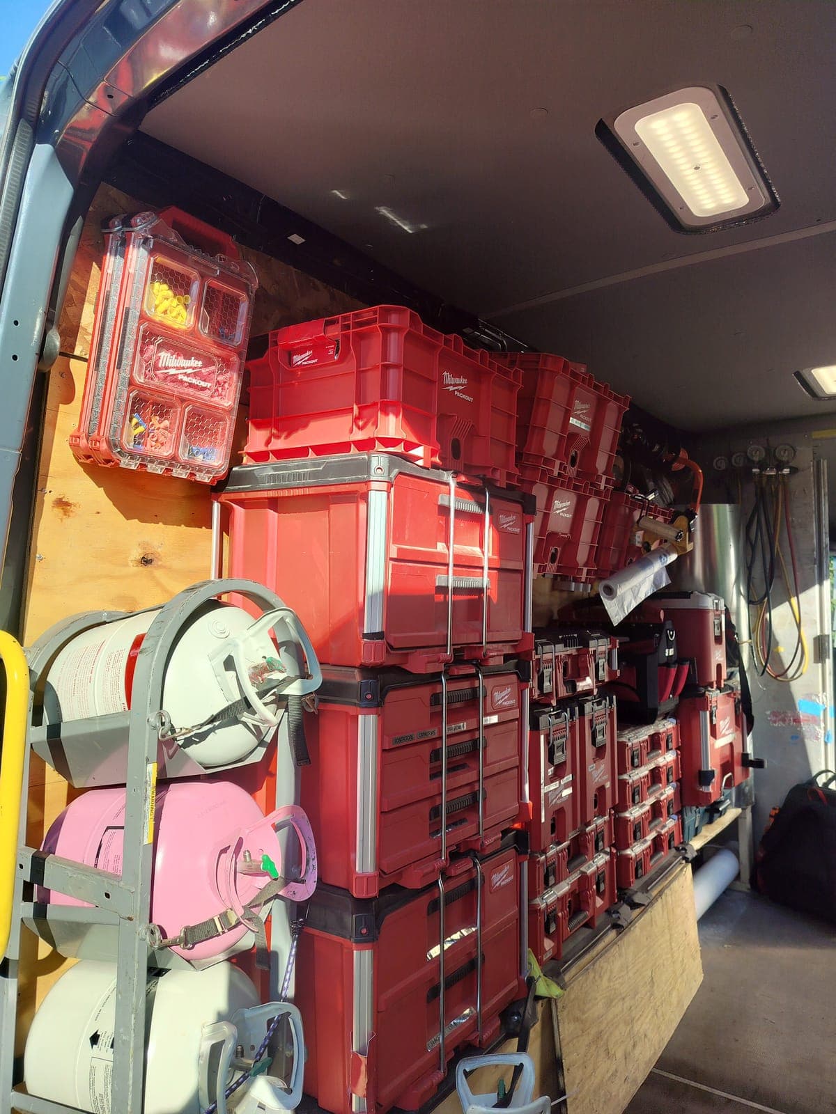 A fully stocked AMW service van loaded with racked Milwaukee Packout tool cases and equipment, ready for first-visit HVAC repairs